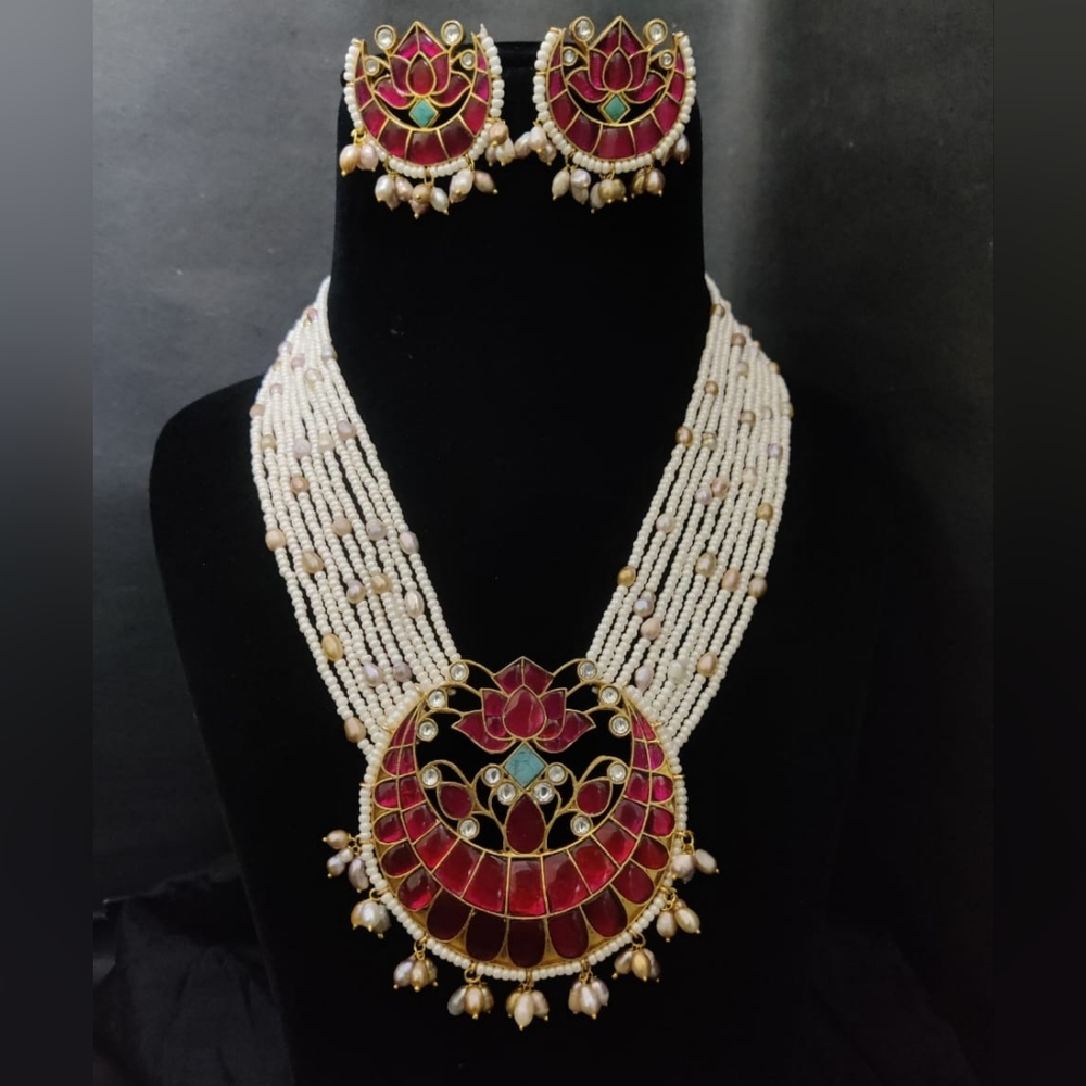 Intricately crafted jadau pendant set beautified with pearl strings.